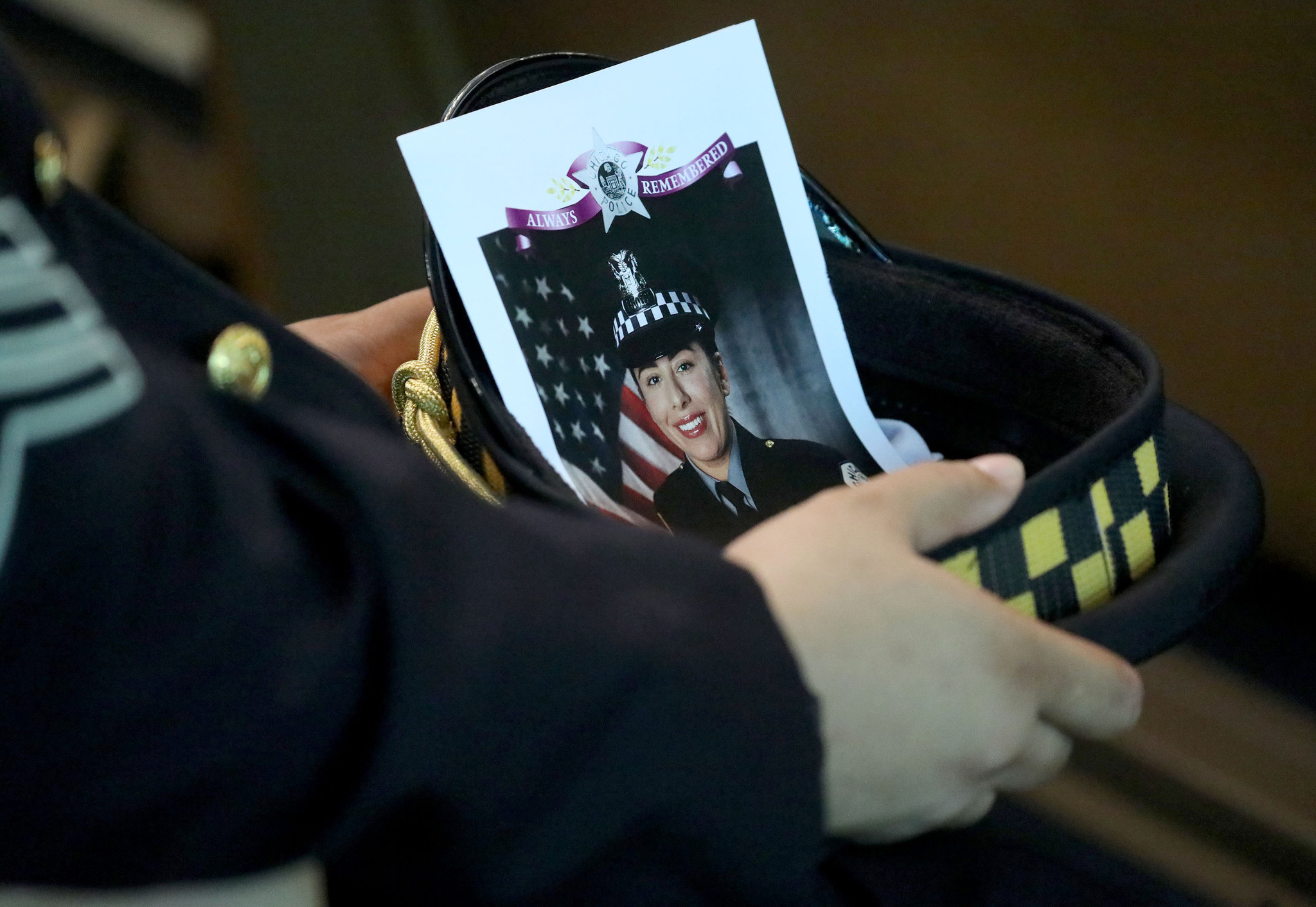 A police officer carries the image of fellow Officer Ella...