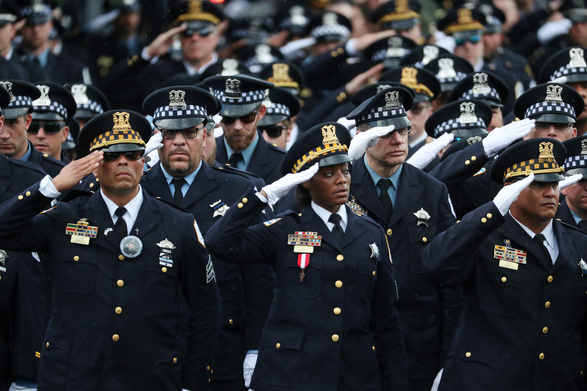 Police officers salute at the funeral for Chicago police Officer...