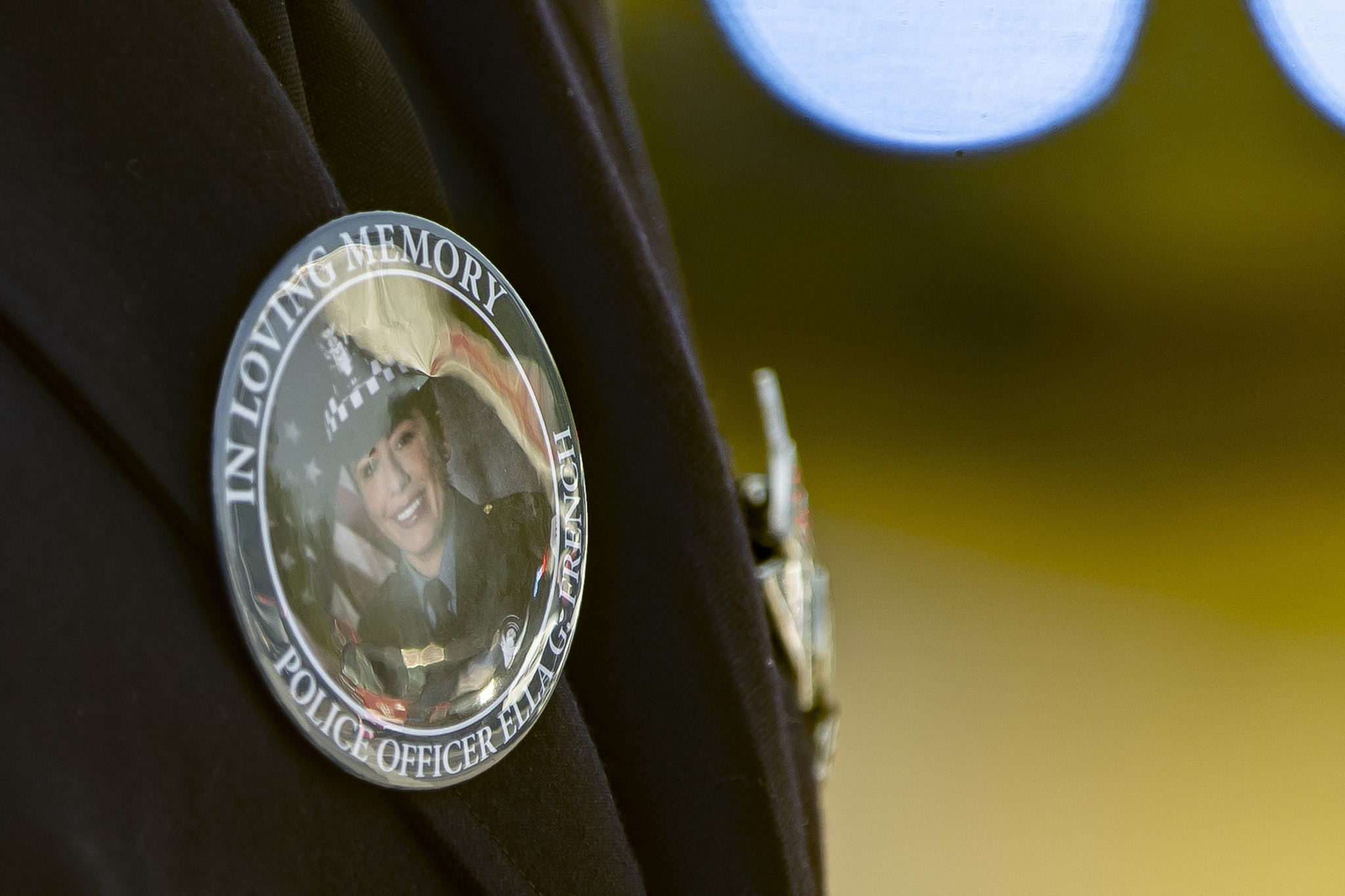 A police officer wears a memorial button at the funeral...