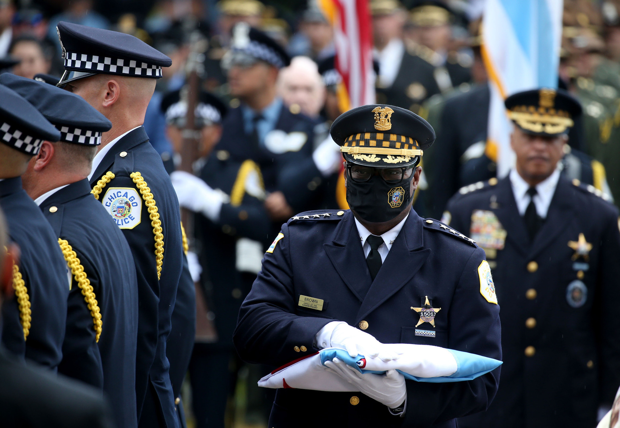 Chicago police Superintendent David Brown carries a folded Chicago flag...