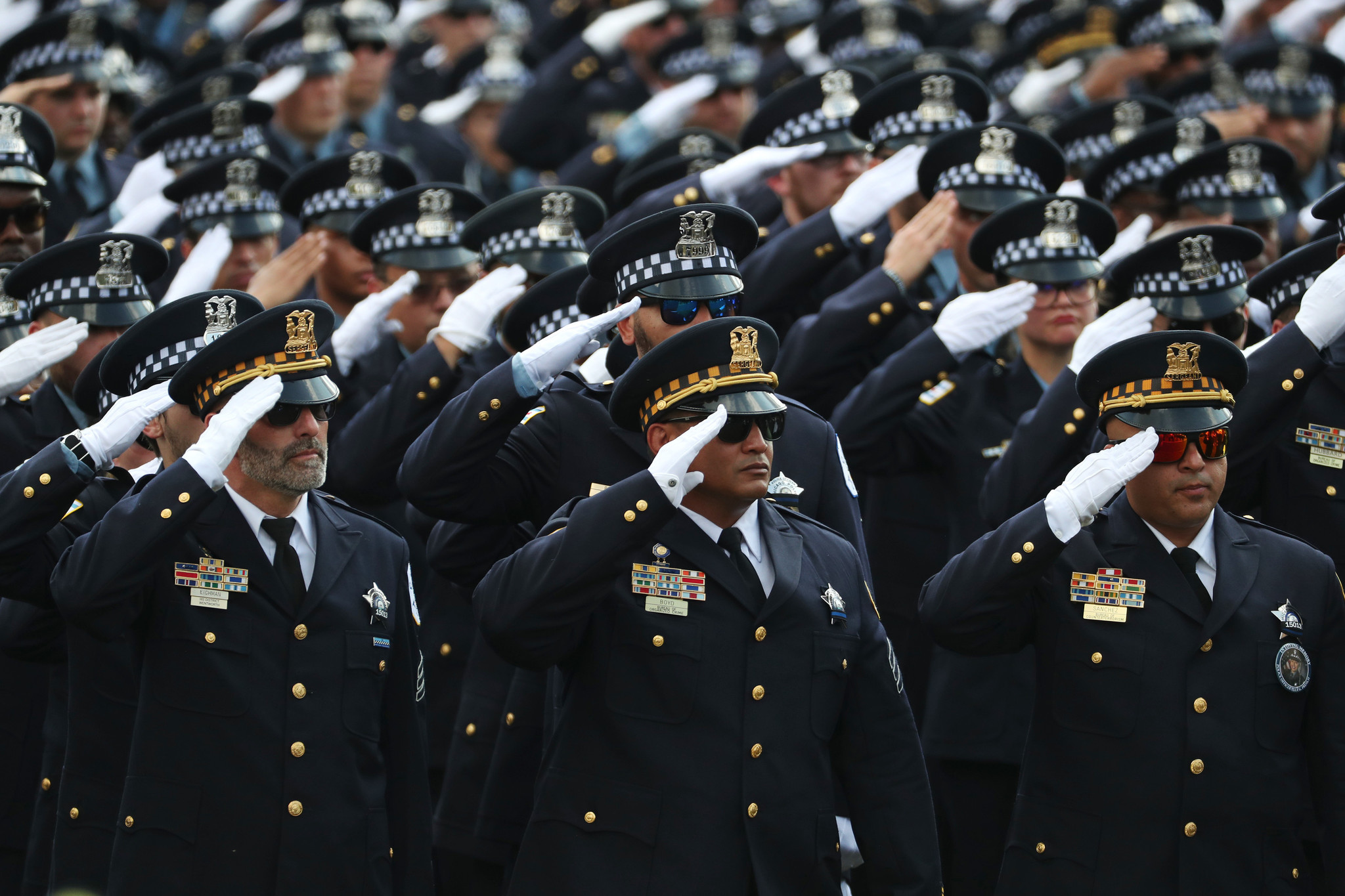 Police officers salute as the casket carrying the body of...