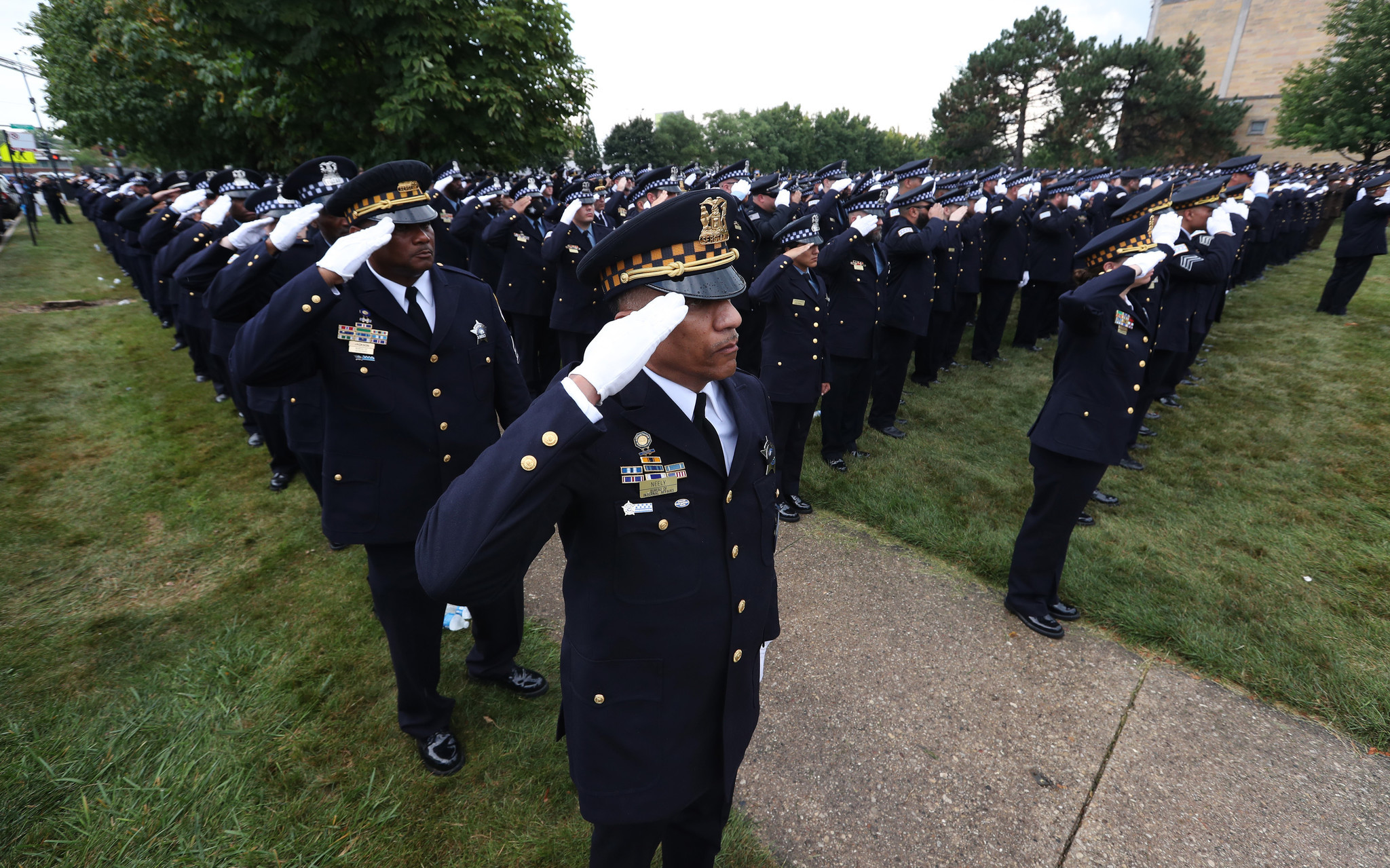 Police officers salute at the funeral for Chicago police Officer...