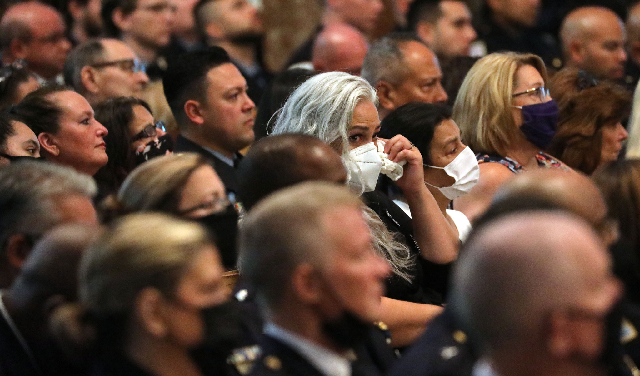 A woman wipes away her tears at the funeral Mass...