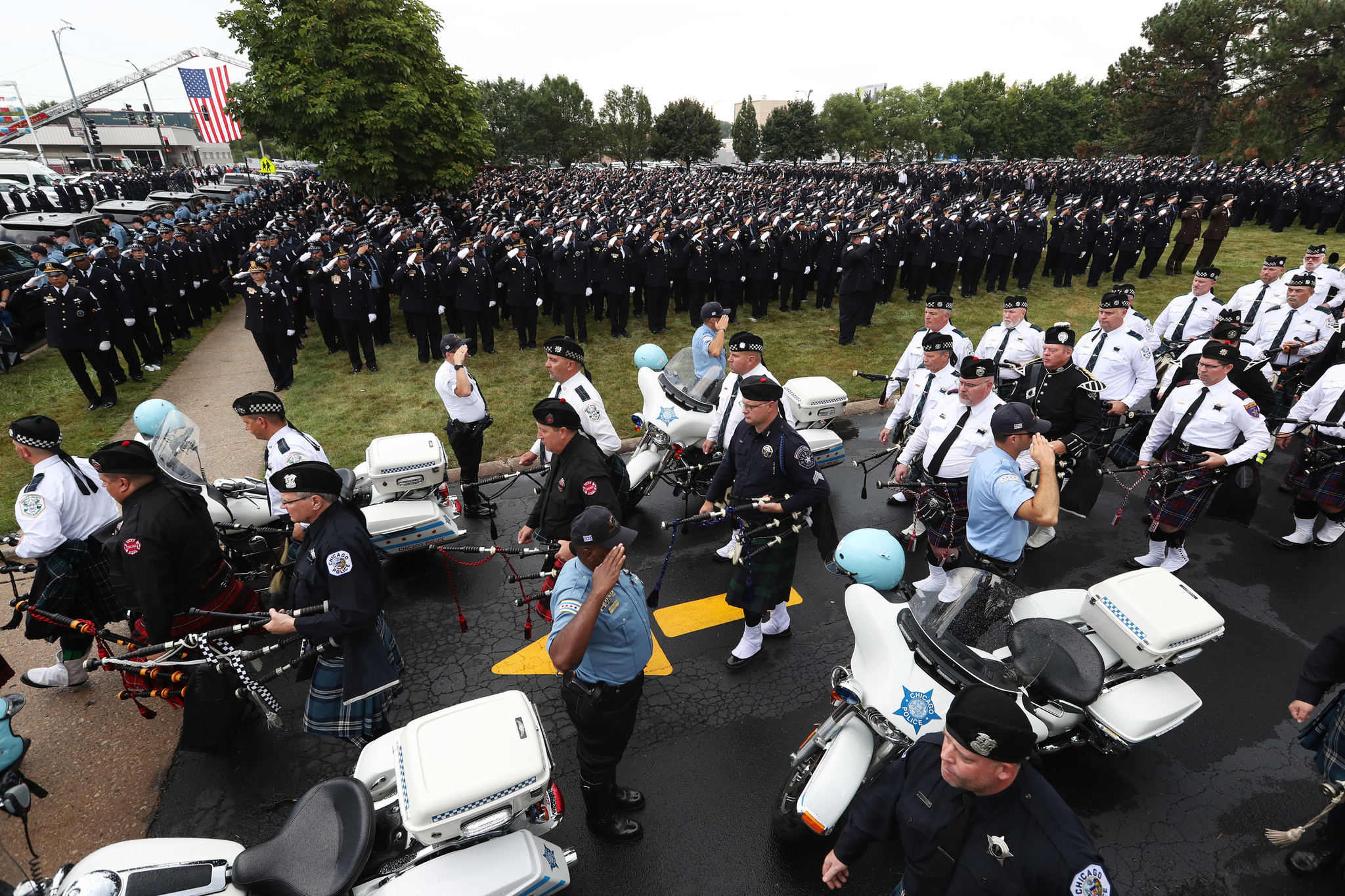 Police officers salute at the funeral for Chicago police Officer...