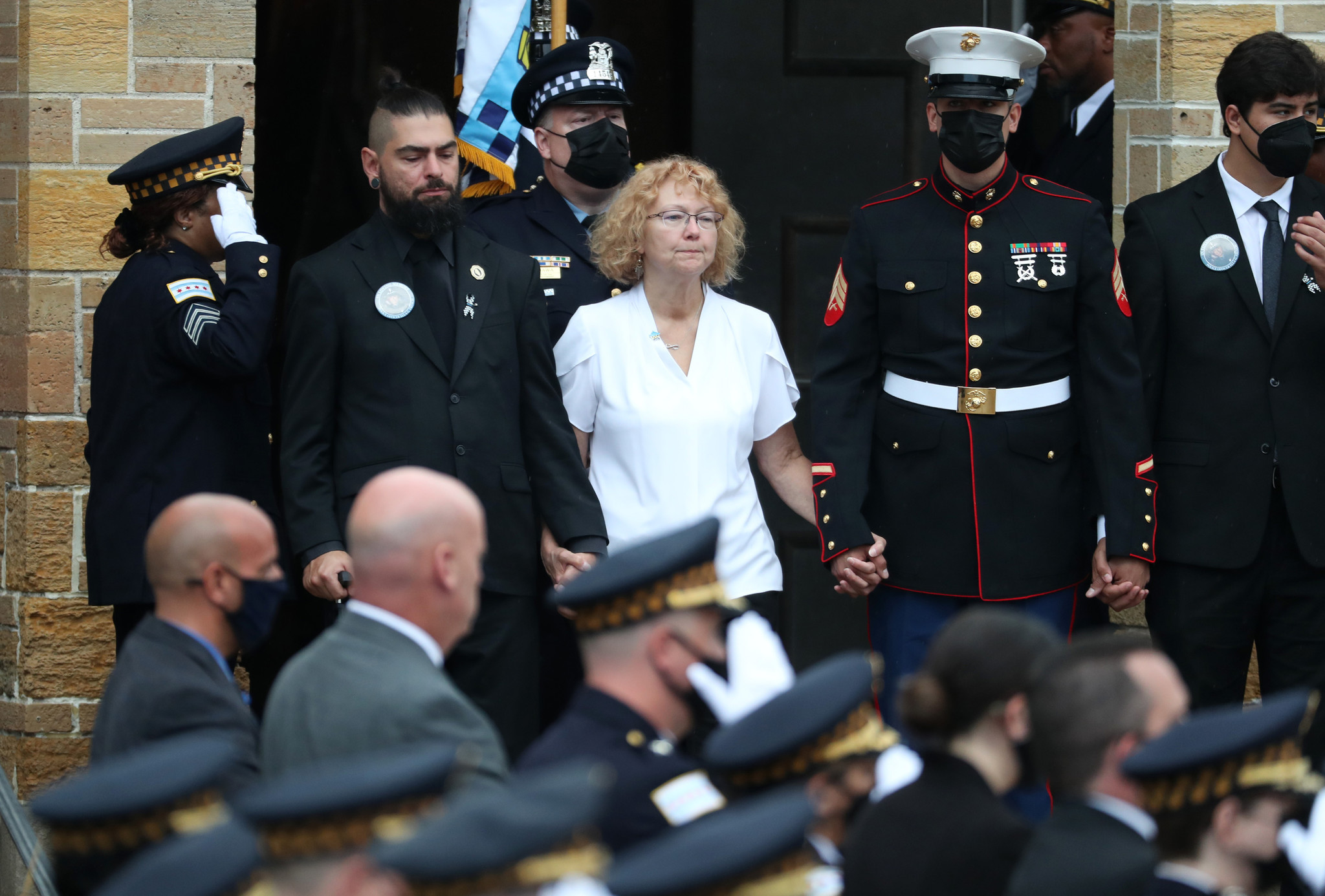 Elizabeth French, center, and her son, Andrew, left, follow the...