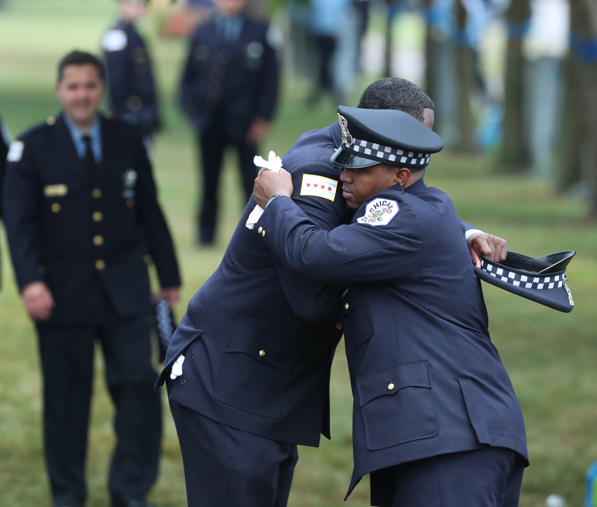 Police officers hug each other after the funeral Mass for...