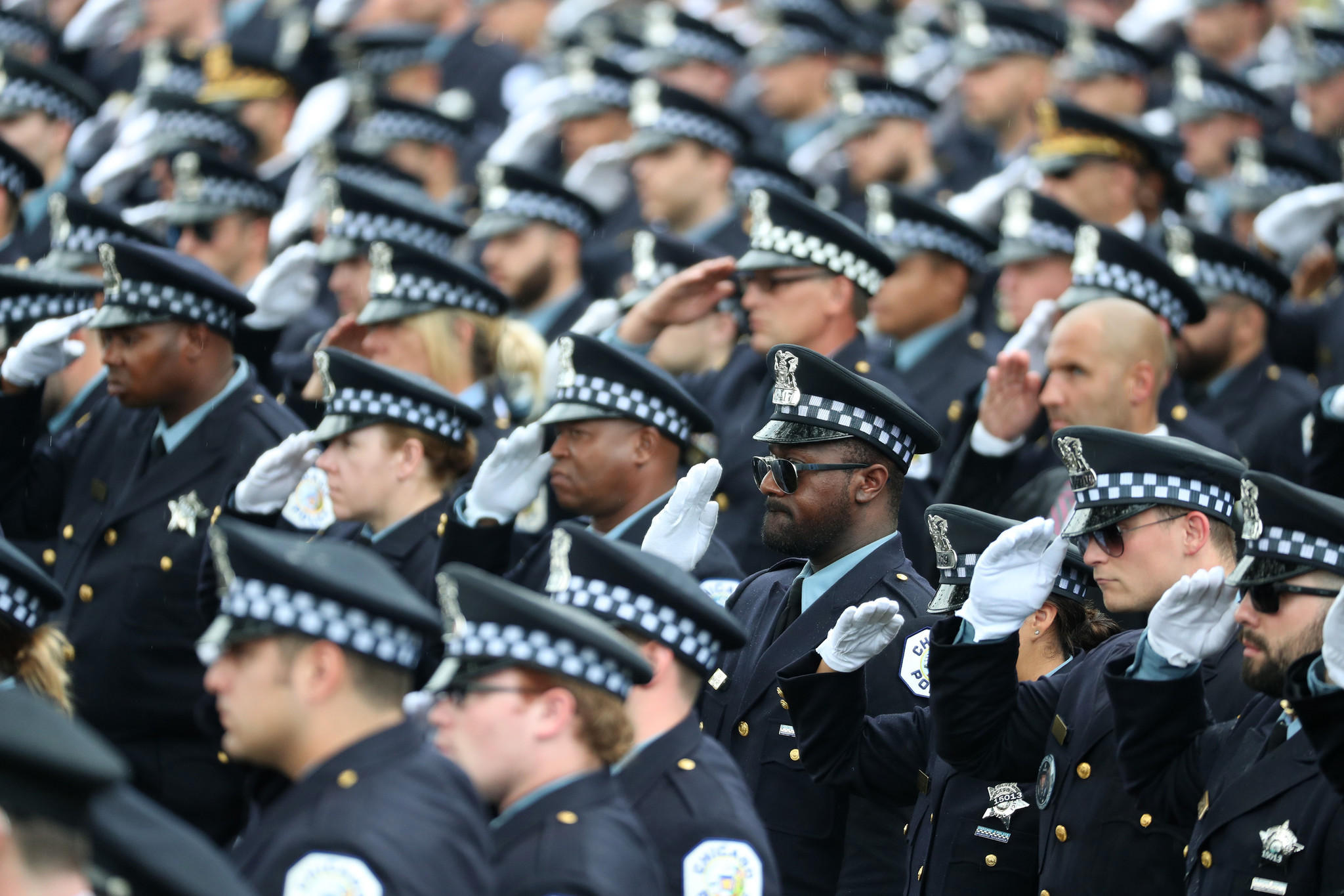 Police officers salute at the funeral for Chicago police Officer...