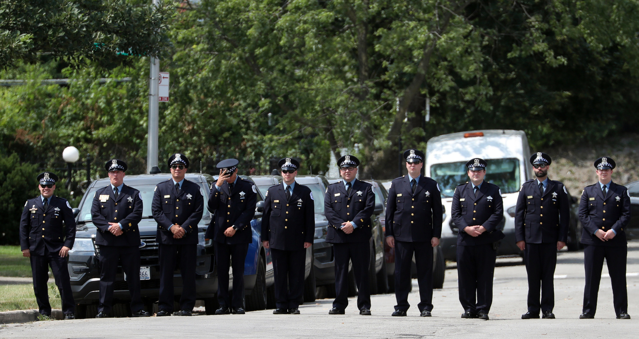 Chicago police await the hearse carrying the flag-draped casket bearing...