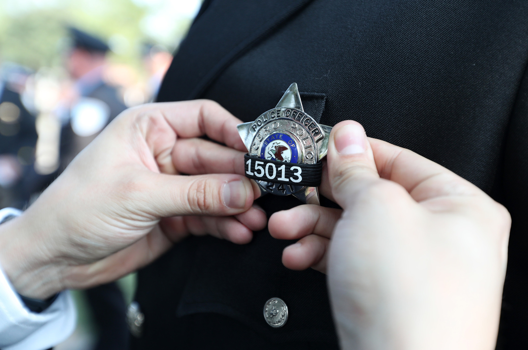 Cicero police Officer Eduardo Diaz adjusts the badge of fellow...