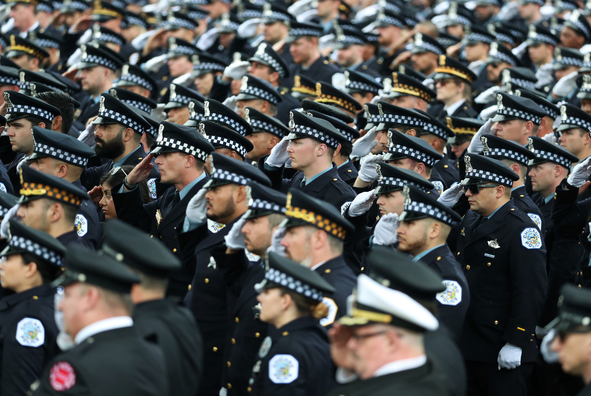 Police officers salute at the funeral for Chicago police Officer...