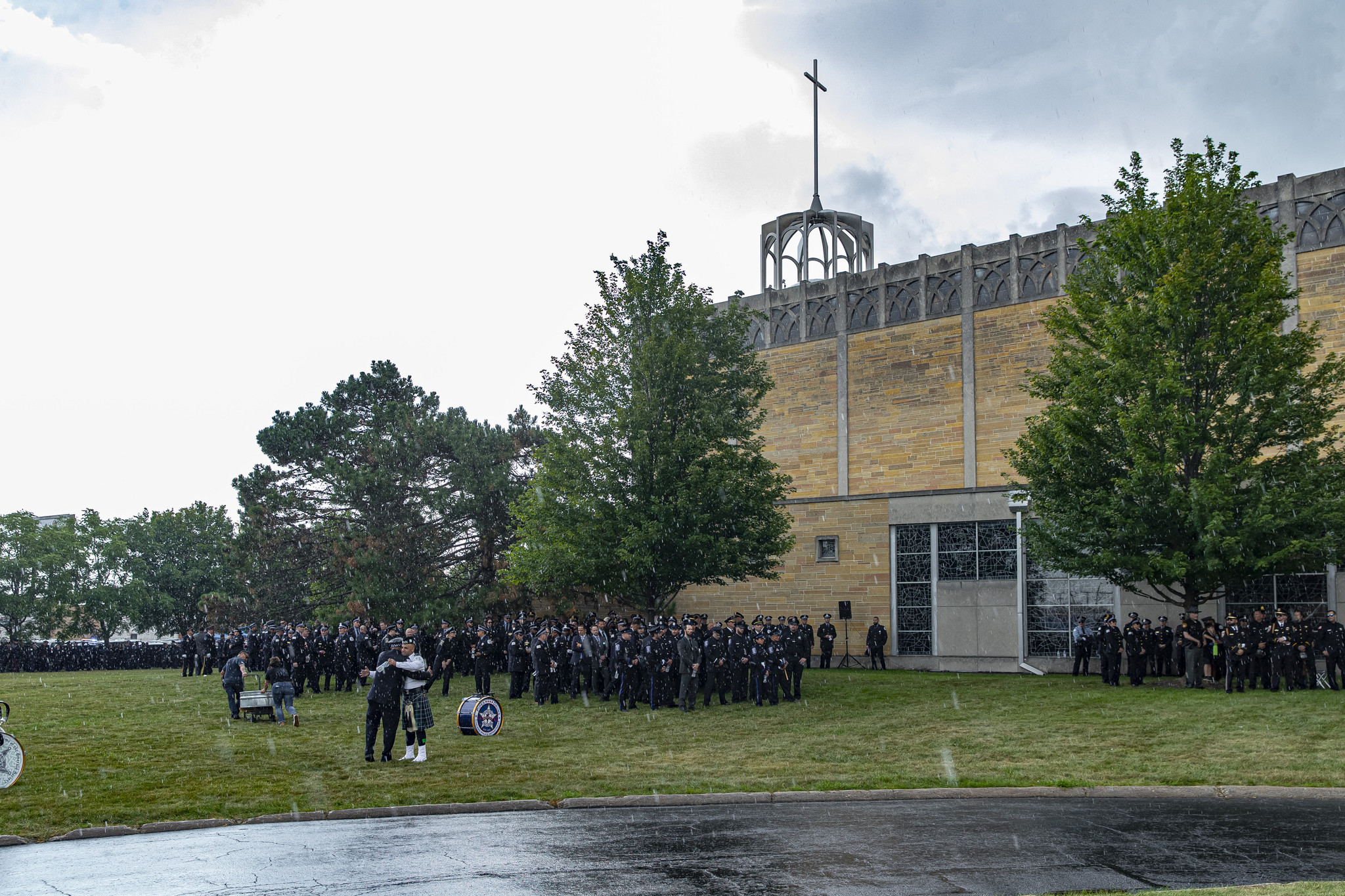 Chicago police officers stand and embrace while in the pouring...