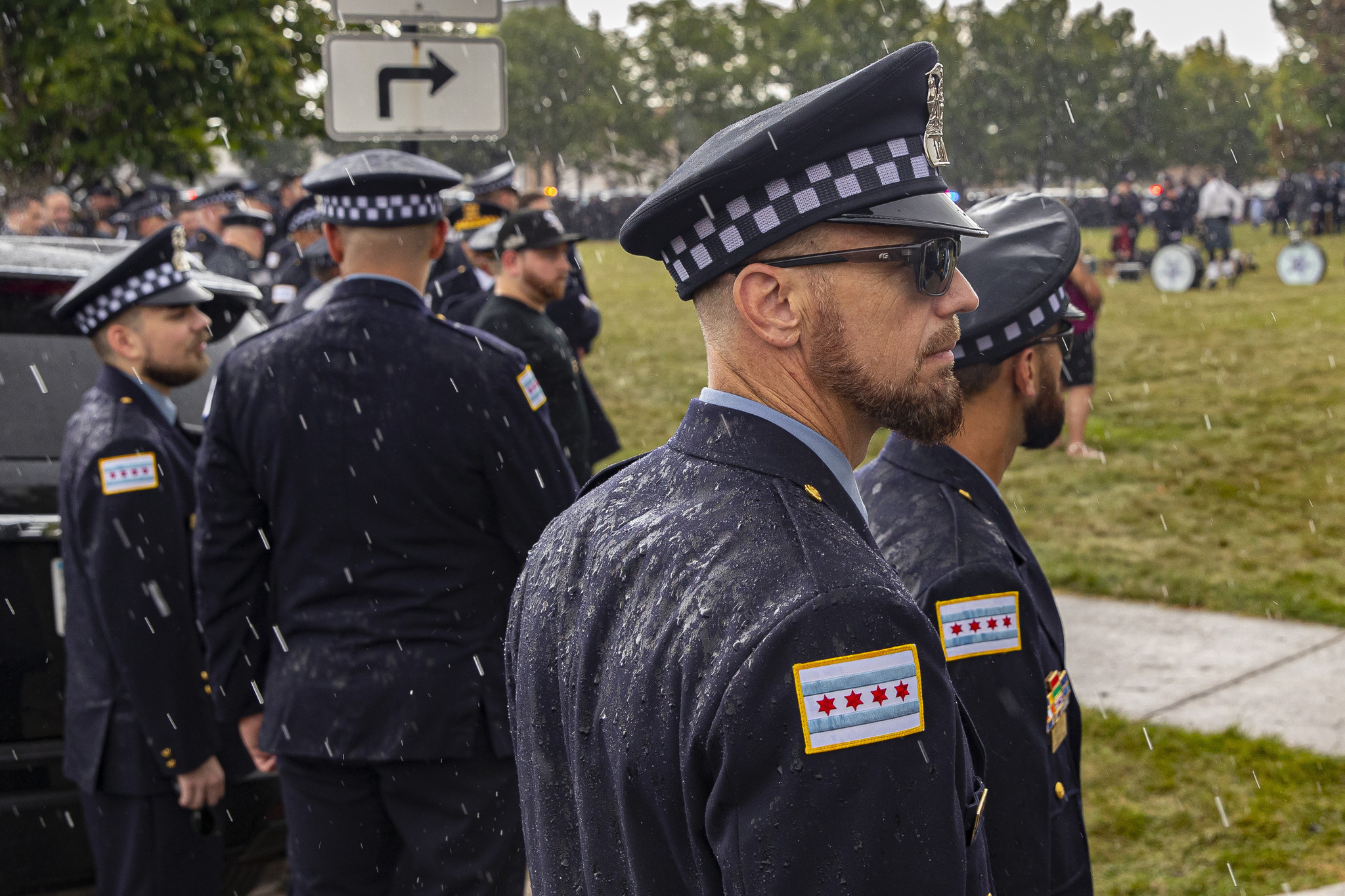 Chicago police officers stand in the pouring rain less than...