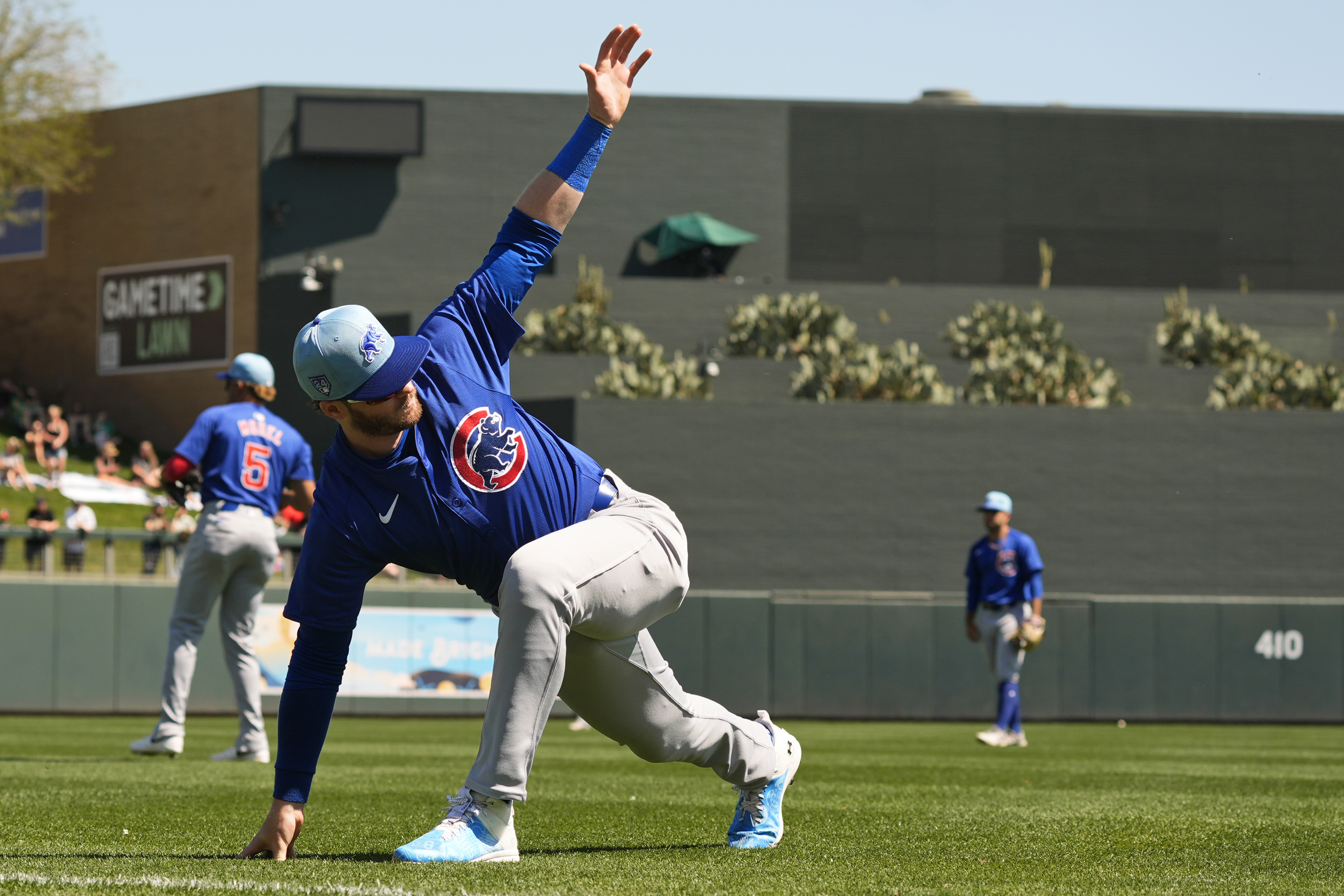 Cubs left fielder Ian Happ stretches before a Cactus League game against the Rockies on March 21, 2024, in Scottsdale, Ariz. (Ross D. Franklin/AP)