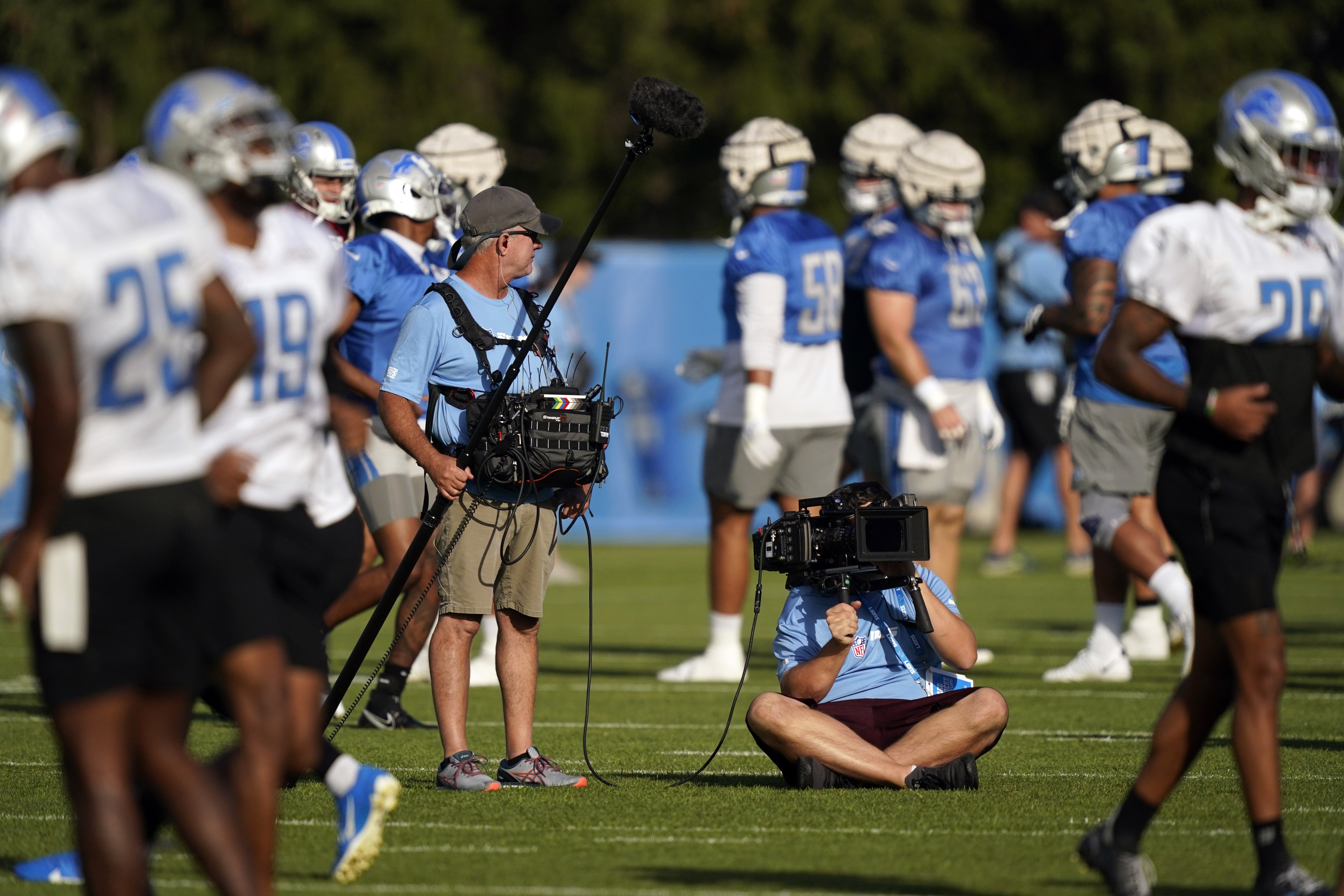 A crew from the HBO series Hard Knocks shoots warmups before drills at the Lions NFL football practice facility, Wednesday, Aug. 10, 2022, in Allen Park, Mich. (AP Photo/Carlos Osorio)