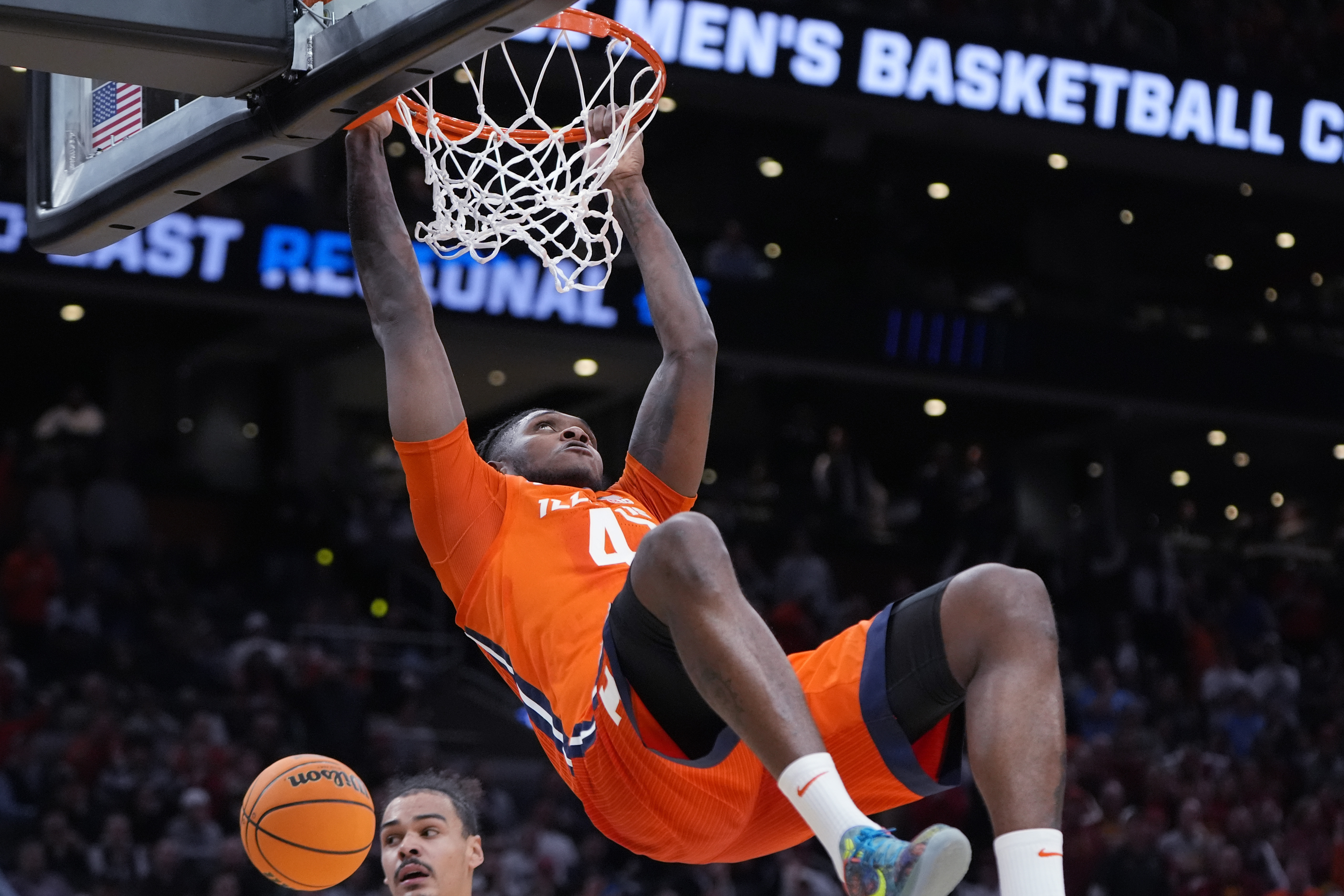 Illinois forward Dain Dainja (42) hangs on the rim after a dunk against Iowa State during the second half of the Sweet 16 college basketball game in the men's NCAA Tournament, Friday, March 29, 2024, in Boston. (AP Photo/Michael Dwyer)
