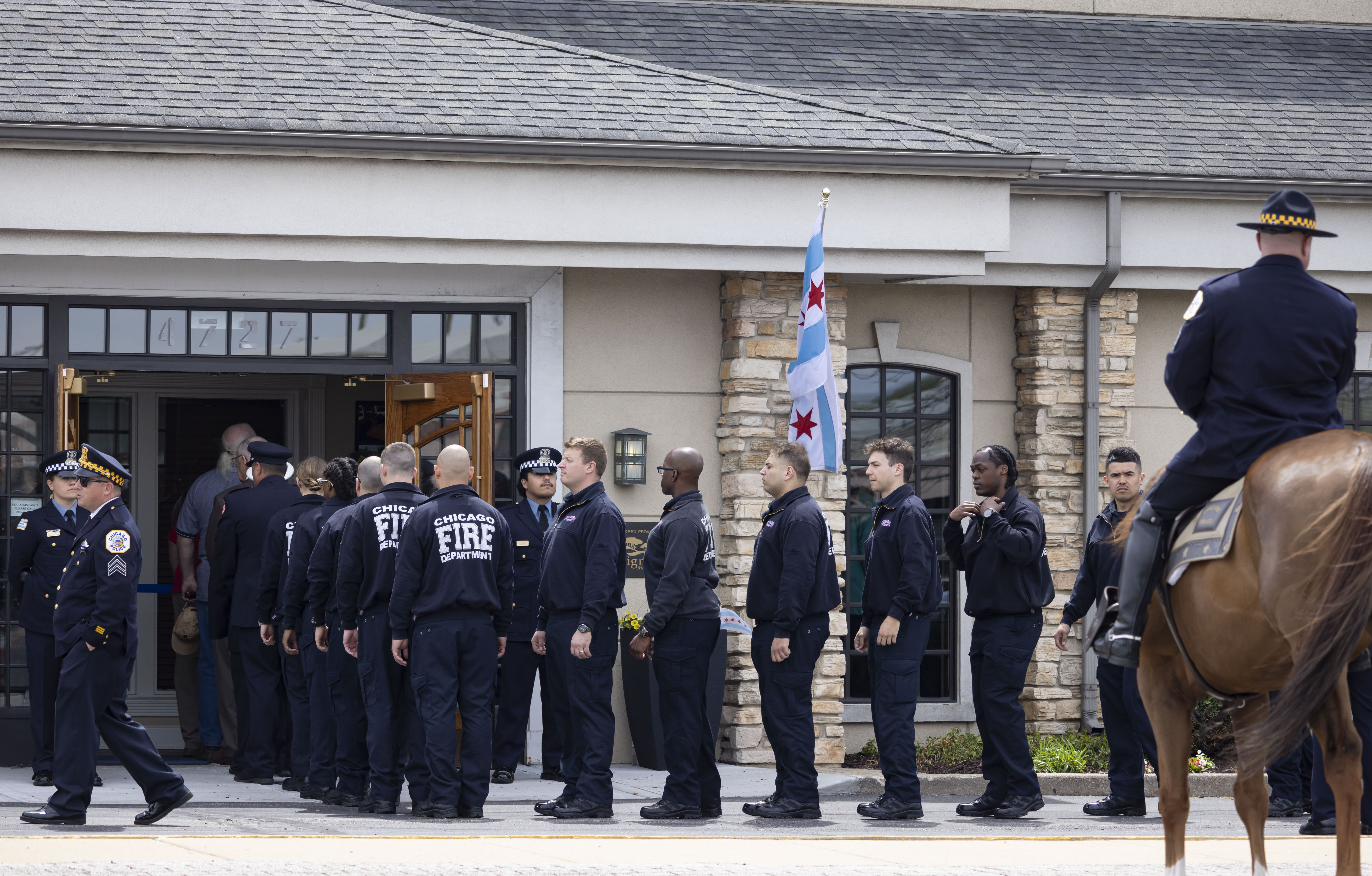 Members of the Chicago Fire Department are among those lining up to enter the visitation for Chicago police Officer Luis M. Huesca on April 28, 2024, at Blake-Lamb Funeral Home in Oak Lawn. (Brian Cassella/Chicago Tribune)