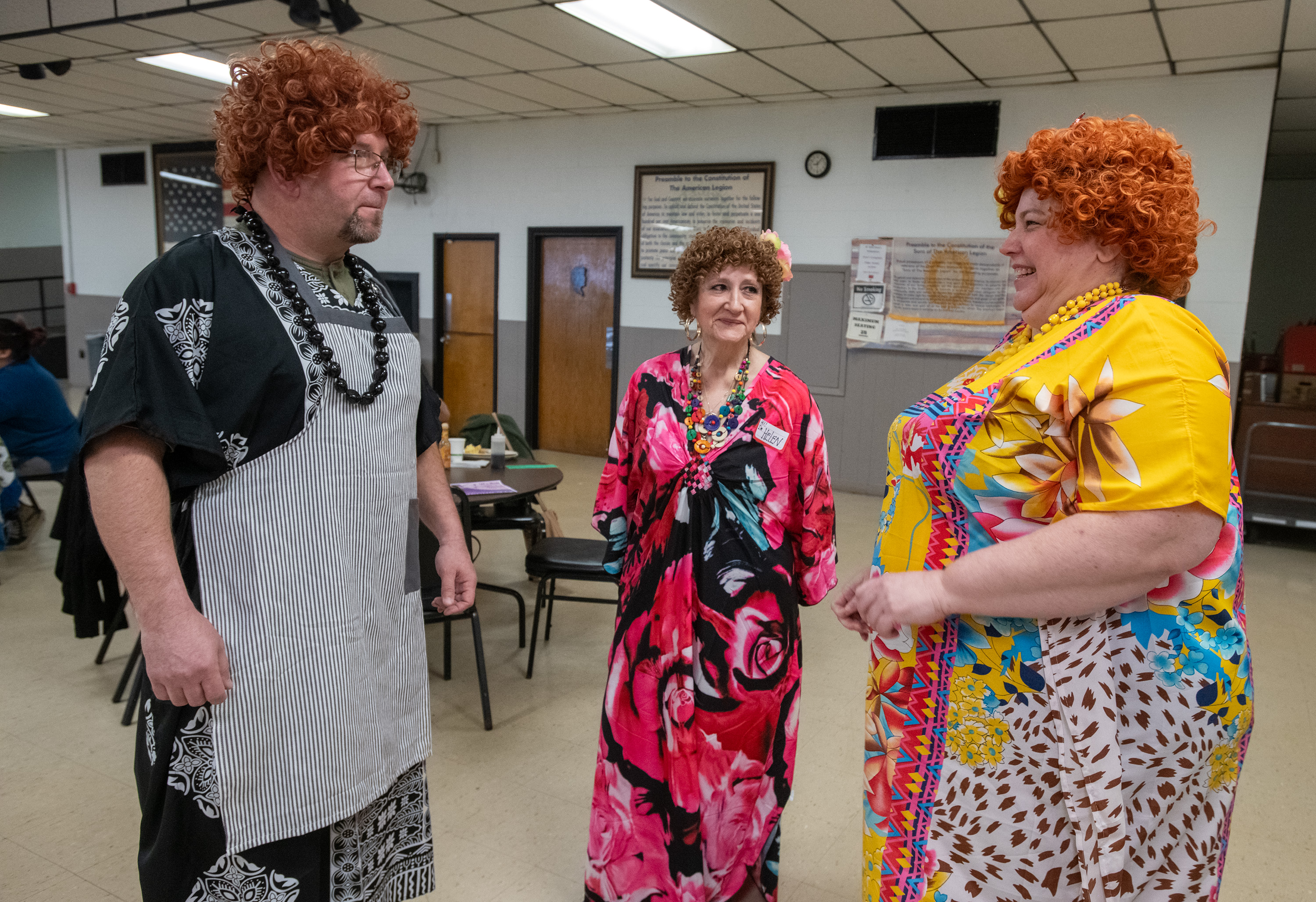 Niki Miller, right, of Valparaiso, laughs as Russell Simola, of Portage, shows off his best Mrs.Roper outfit while Karen Musto, of St. John, looks on prior to the start of breakfast service at the American Legion Post 100 in Lake Station, Indiana, on Sunday, April 21, 2024. The International Order of Mrs. Ropers, Northwest Indiana Chapter volunteered to serve breakfast for the day. (Andy Lavalley for the Post-Tribune)