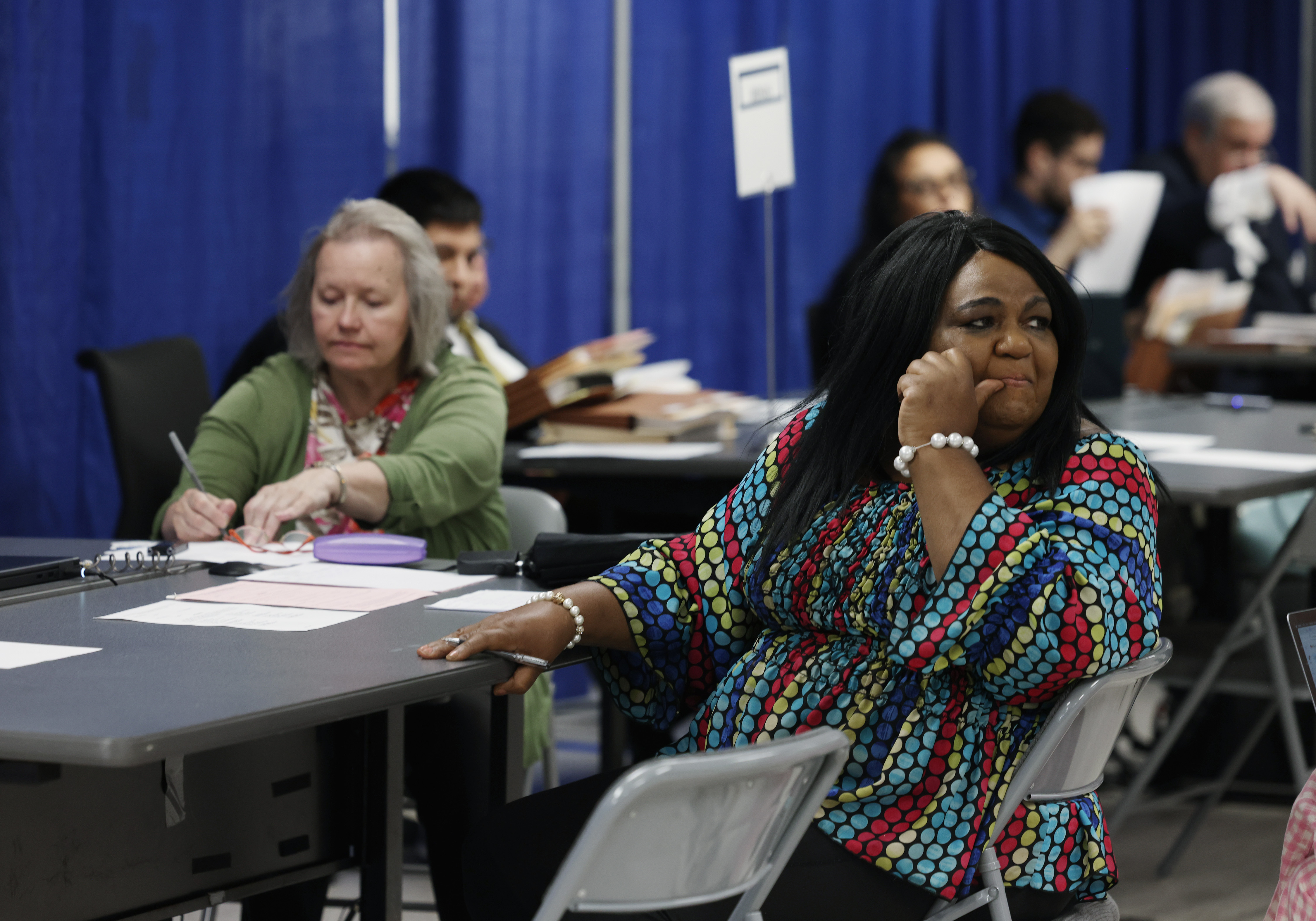 Rosita Chatonda, school board candidate for the 10th District, right, watches activity around her during an initial objections hearing for school board candidates at a Board of Elections meeting room at 69 W. Washington St. on July 9, 2024, in Chicago. (John J. Kim/Chicago Tribune)