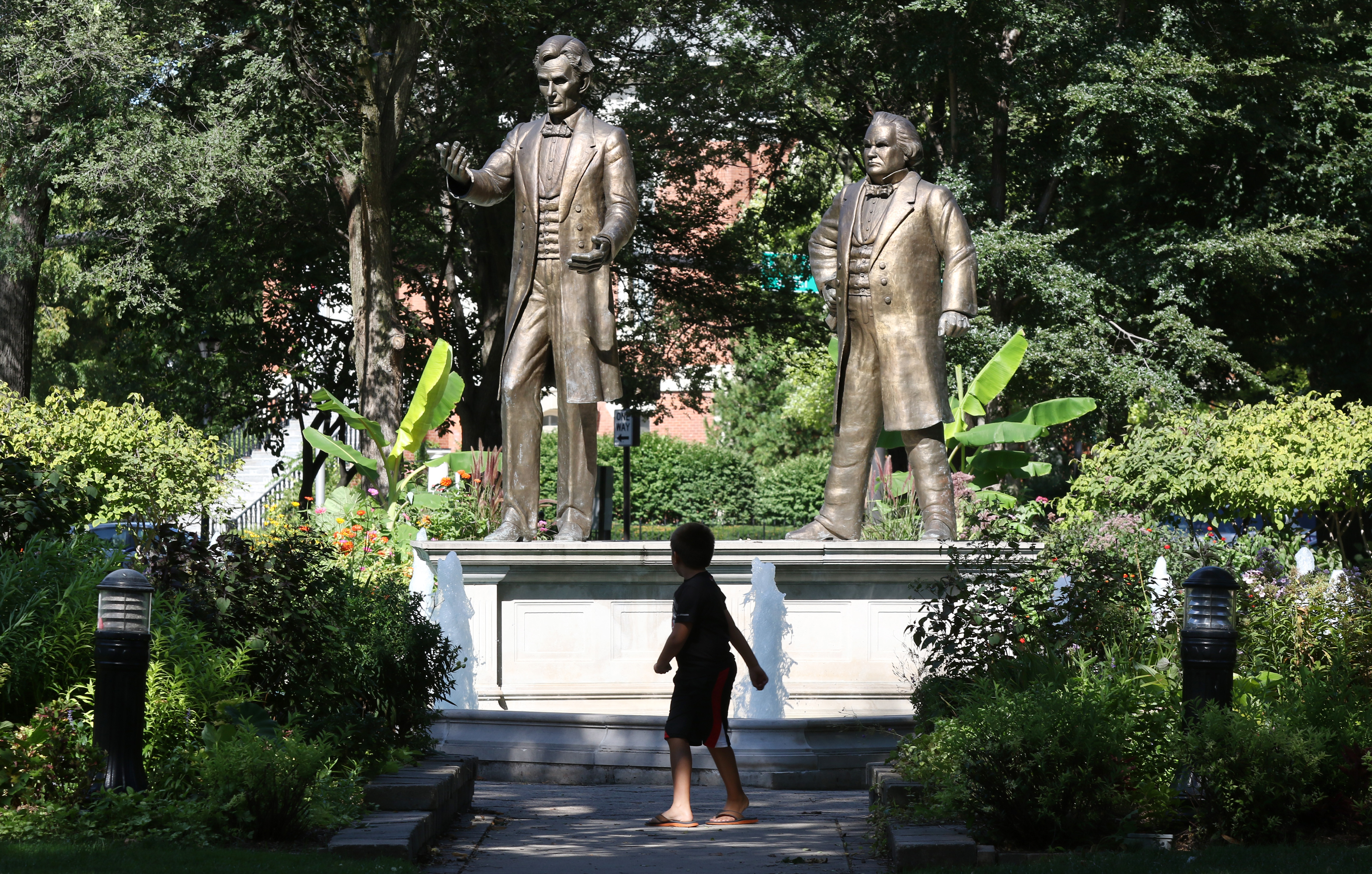 A child stands in front of statues of Abraham Lincoln, left, and Stephen A. Douglas in Ottawa, Illinois. The park is where they first debated. (John J. Kim/Chicago Tribune)