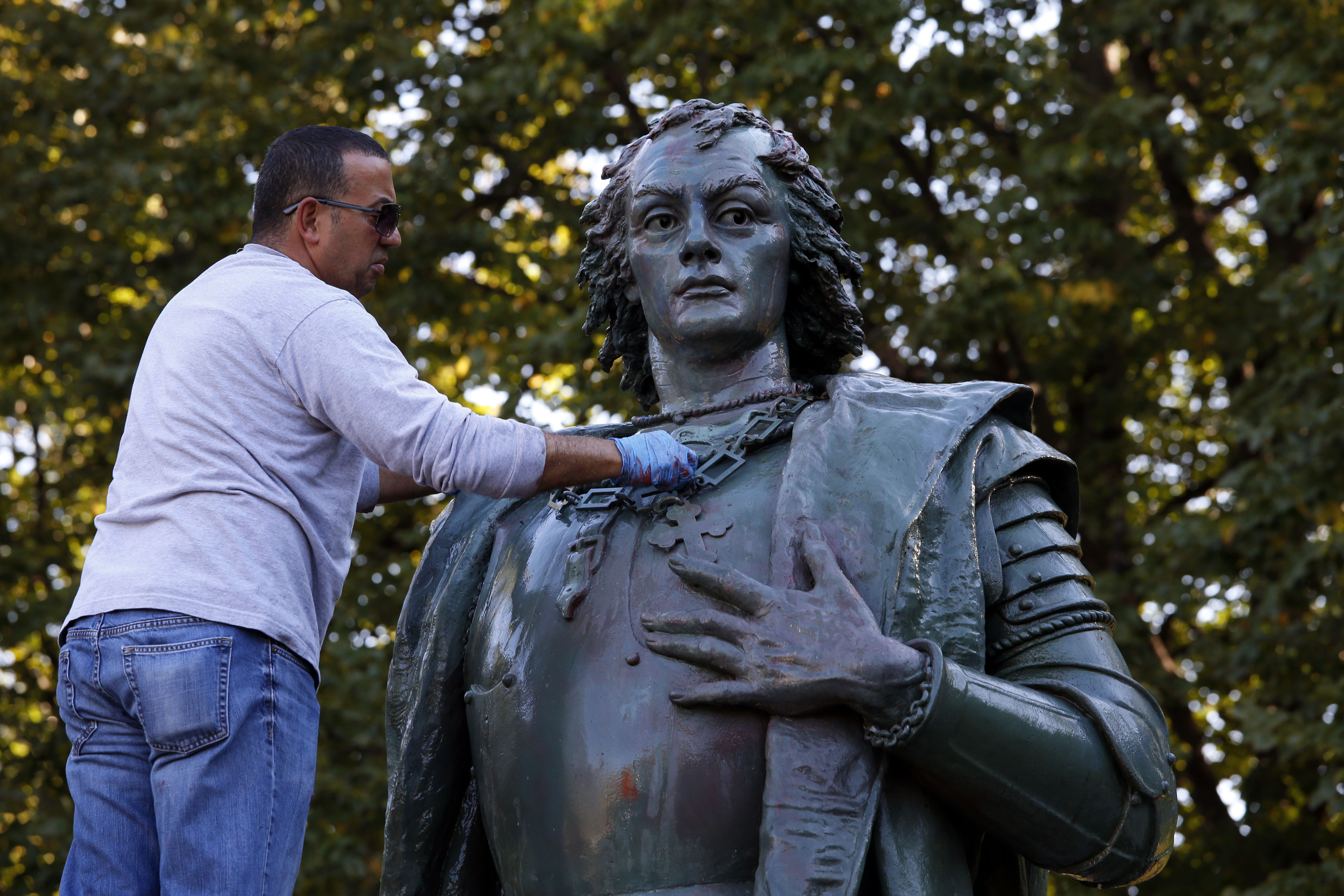 Chicago Park District worker Jose Troche finishes removing red paint that was sprayed on the Christopher Columbus statue, Oct. 9, 2017, in Arrigo Park. (Phil Velasquez/Chicago Tribune)